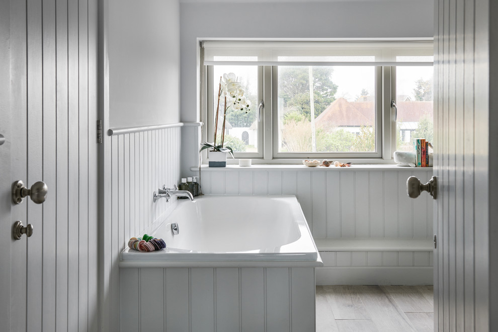 This is an example of a small beach style family bathroom in Hampshire with flat-panel cabinets, grey cabinets, a built-in bath and grey walls.