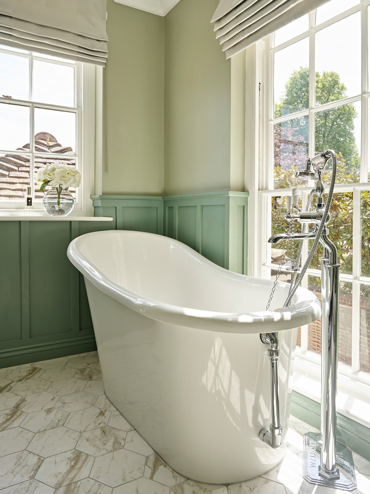 Design ideas for a traditional bathroom in London with a freestanding bath, green walls and white floors.