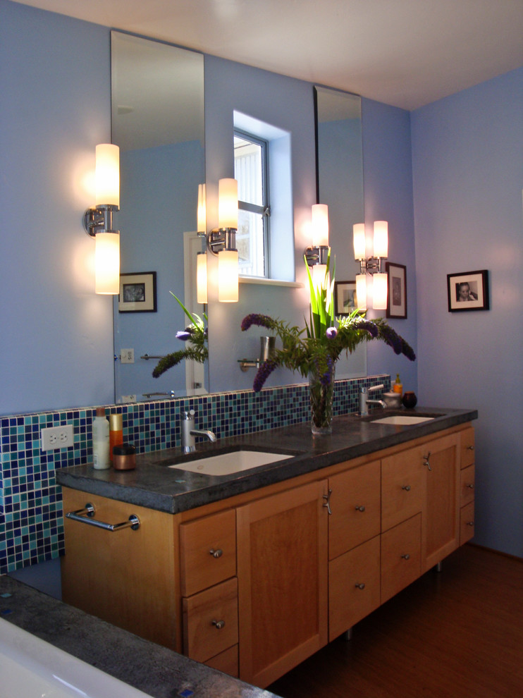 Esempio di una stanza da bagno con doccia bohémian di medie dimensioni con ante con riquadro incassato, ante in legno scuro, vasca ad alcova, piastrelle nere, pavimento in legno massello medio, lavabo da incasso, top in granito e pareti blu