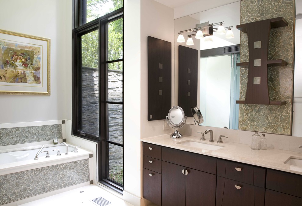 Modelo de cuarto de baño contemporáneo con armarios con paneles lisos, puertas de armario de madera en tonos medios, bañera encastrada sin remate y baldosas y/o azulejos grises
