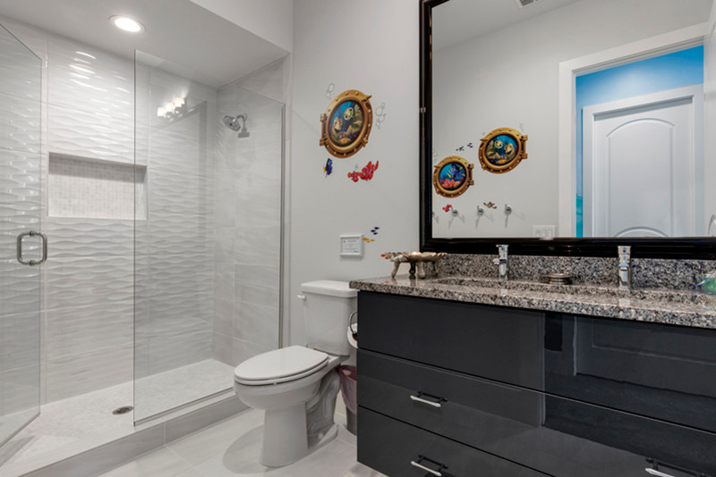 Small modern shower room bathroom in Orlando with flat-panel cabinets, blue cabinets, an alcove shower, a two-piece toilet, multi-coloured tiles, glass tiles, white walls, porcelain flooring, a built-in sink and engineered stone worktops.