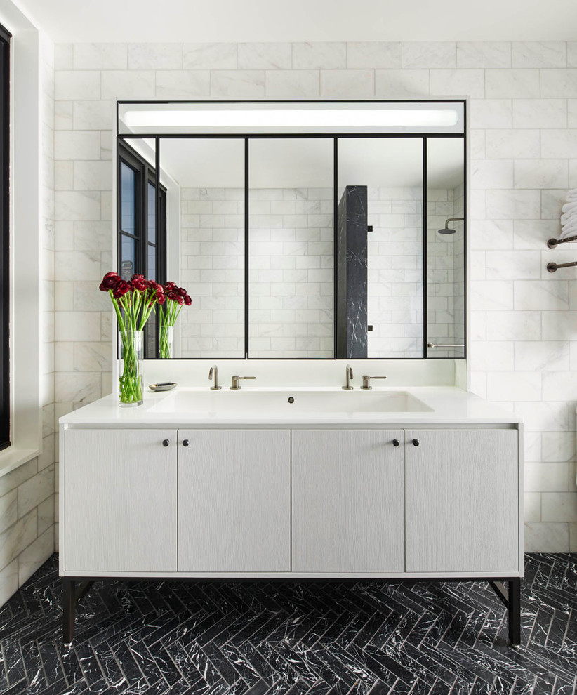 На фото: главная ванная комната в современном стиле с монолитной раковиной, плоскими фасадами, серыми фасадами, белой плиткой и мраморным полом с