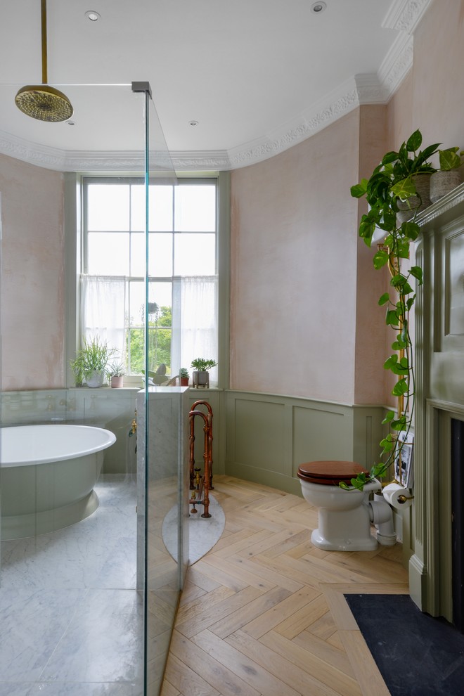 Inredning av ett eklektiskt stort en-suite badrum, med gröna skåp, ett fristående badkar, en öppen dusch, en vägghängd toalettstol, ett nedsänkt handfat, marmorbänkskiva och med dusch som är öppen