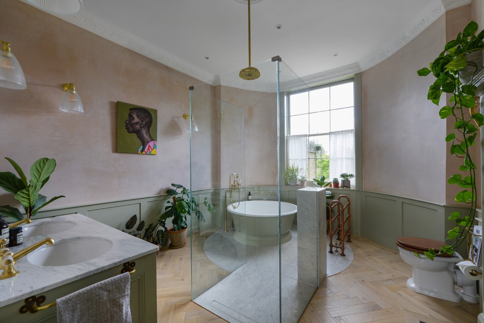 Diseño de cuarto de baño principal bohemio grande con puertas de armario verdes, bañera exenta, ducha abierta, sanitario de pared, lavabo encastrado, encimera de mármol y ducha abierta