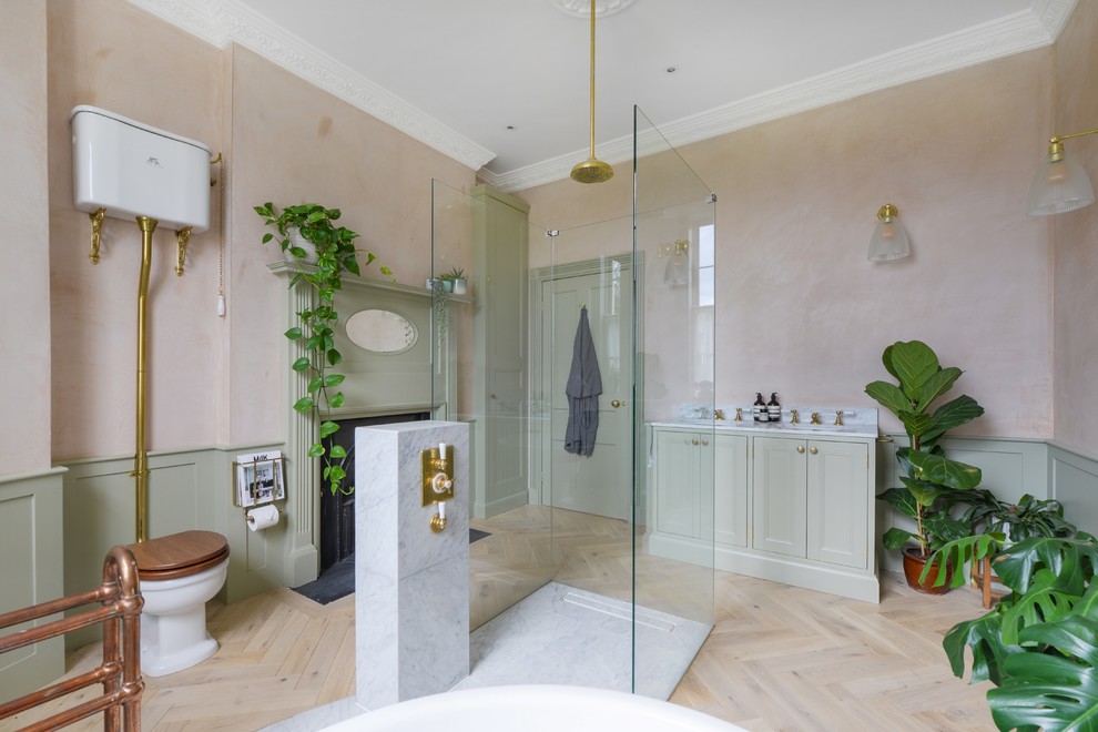 Ejemplo de cuarto de baño principal ecléctico grande con puertas de armario verdes, bañera exenta, ducha abierta, sanitario de pared, lavabo encastrado, encimera de mármol y ducha abierta