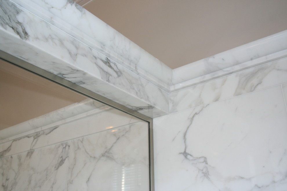 Large transitional master white tile and stone slab marble floor corner shower photo in New York with an undermount sink, furniture-like cabinets, dark wood cabinets, marble countertops, an undermount tub, a one-piece toilet and white walls
