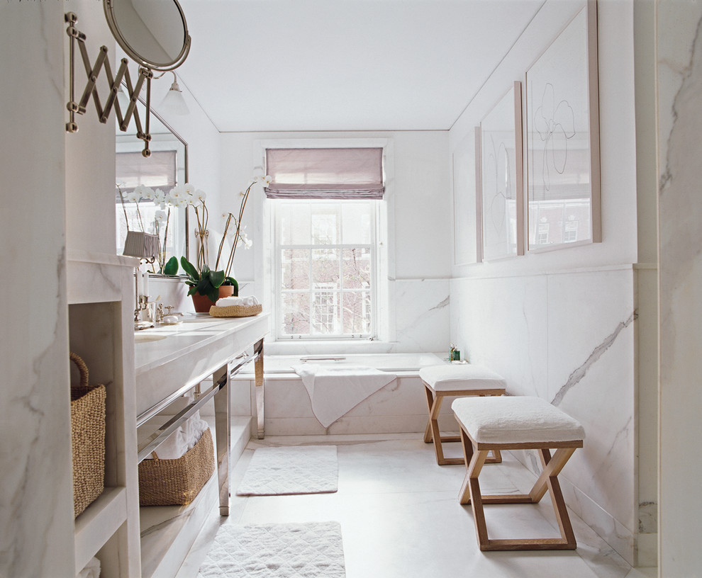 На фото: ванная комната в стиле неоклассика (современная классика) с открытыми фасадами, ванной в нише, плиткой из листового камня, белыми стенами и врезной раковиной