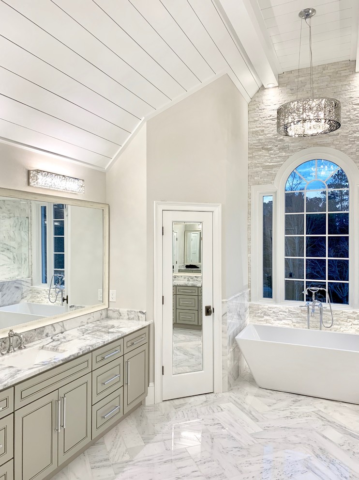 Idéer för att renovera ett vintage grå grått en-suite badrum, med luckor med upphöjd panel, grå skåp, ett fristående badkar, vit kakel, vita väggar, ett undermonterad handfat och grått golv