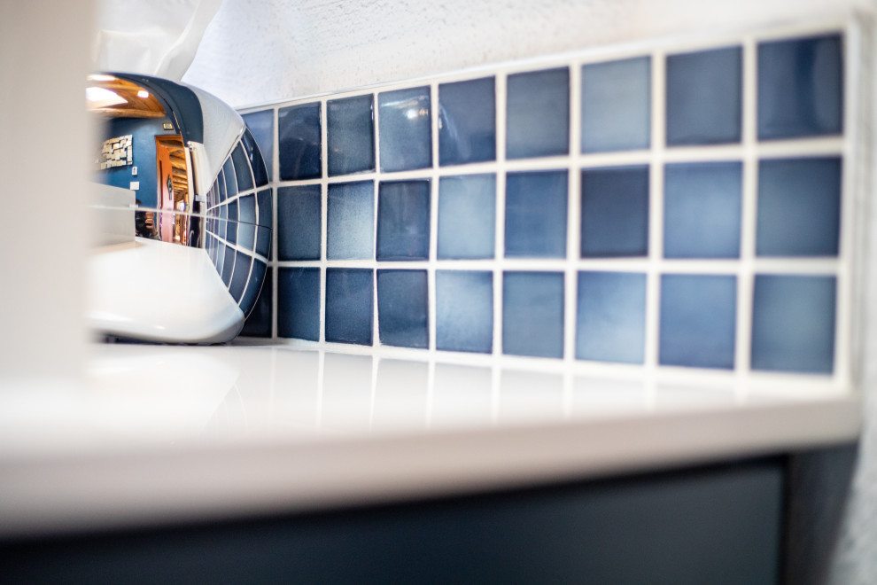 Bild på ett litet eklektiskt vit vitt badrum med dusch, med skåp i shakerstil, blå skåp, en toalettstol med hel cisternkåpa, flerfärgad kakel, klinkergolv i terrakotta, ett piedestal handfat, bänkskiva i kvarts och brunt golv