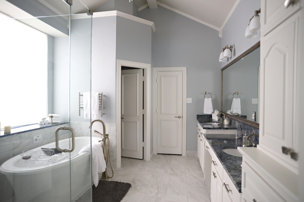 Large traditional ensuite bathroom in Dallas with a submerged sink, white cabinets, a freestanding bath, a corner shower, blue walls and marble flooring.