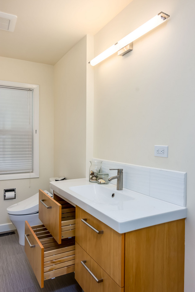 Medium sized traditional family bathroom in Portland with flat-panel cabinets, light wood cabinets, an alcove bath, an alcove shower, a two-piece toilet, white tiles, ceramic tiles, white walls, vinyl flooring, an integrated sink, glass worktops, beige floors, a shower curtain and white worktops.
