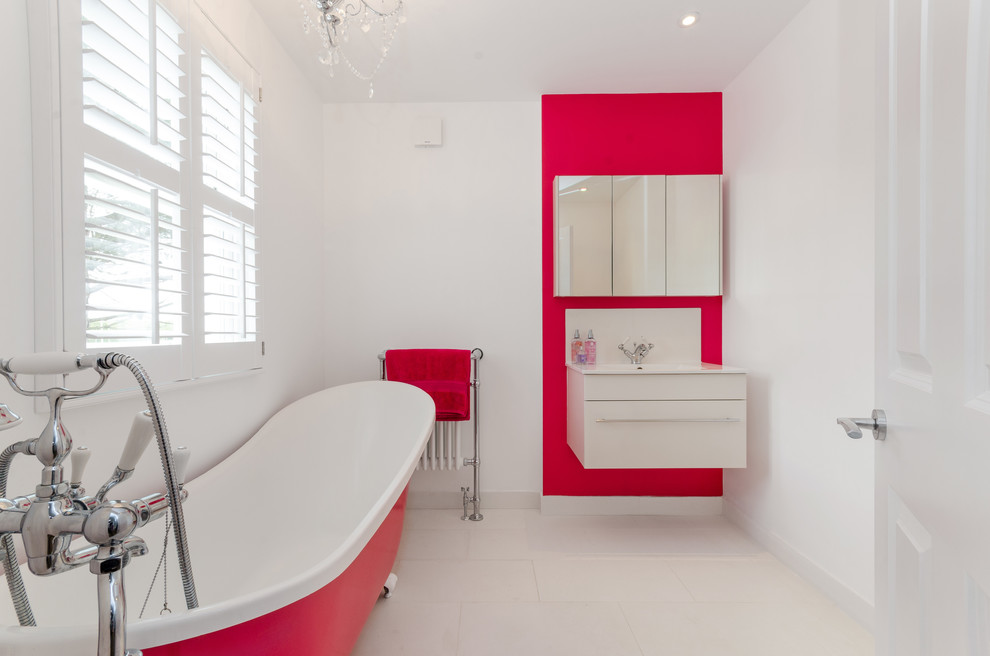 На фото: главная ванная комната среднего размера в современном стиле с плоскими фасадами, белыми фасадами, белыми стенами, подвесной раковиной, бежевым полом и ванной на ножках