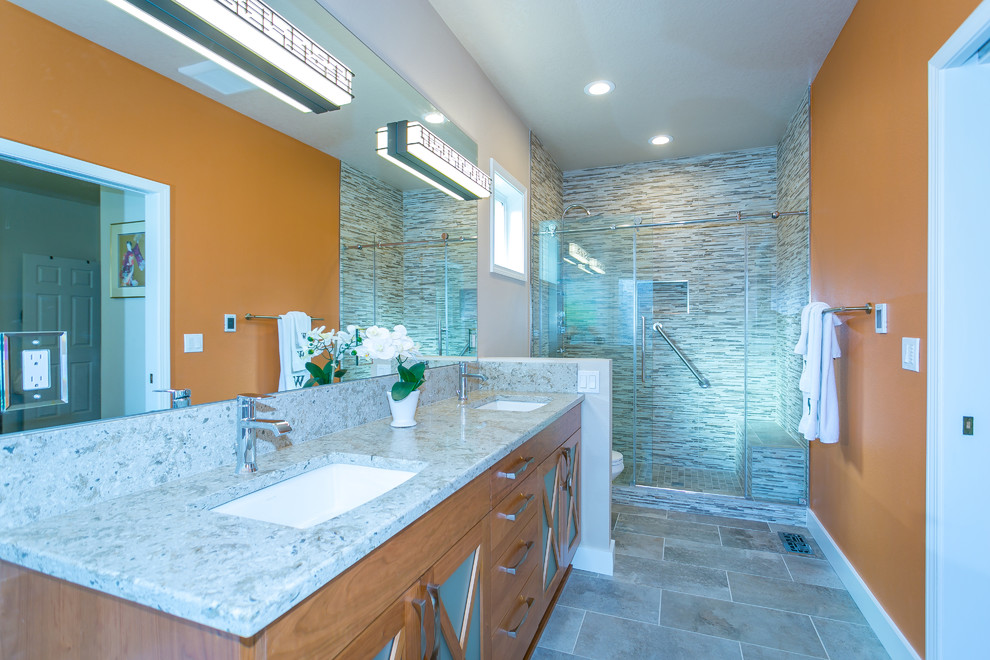 Mid-sized arts and crafts master stone tile porcelain tile and gray floor bathroom photo in Portland with glass-front cabinets, medium tone wood cabinets, an undermount sink, quartz countertops, a hinged shower door and multicolored countertops