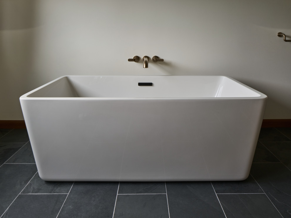 Design ideas for a large modern bathroom in Portland with flat-panel cabinets, medium wood cabinets, a freestanding bath, beige tiles, ceramic tiles, engineered stone worktops, white worktops, double sinks and a freestanding vanity unit.