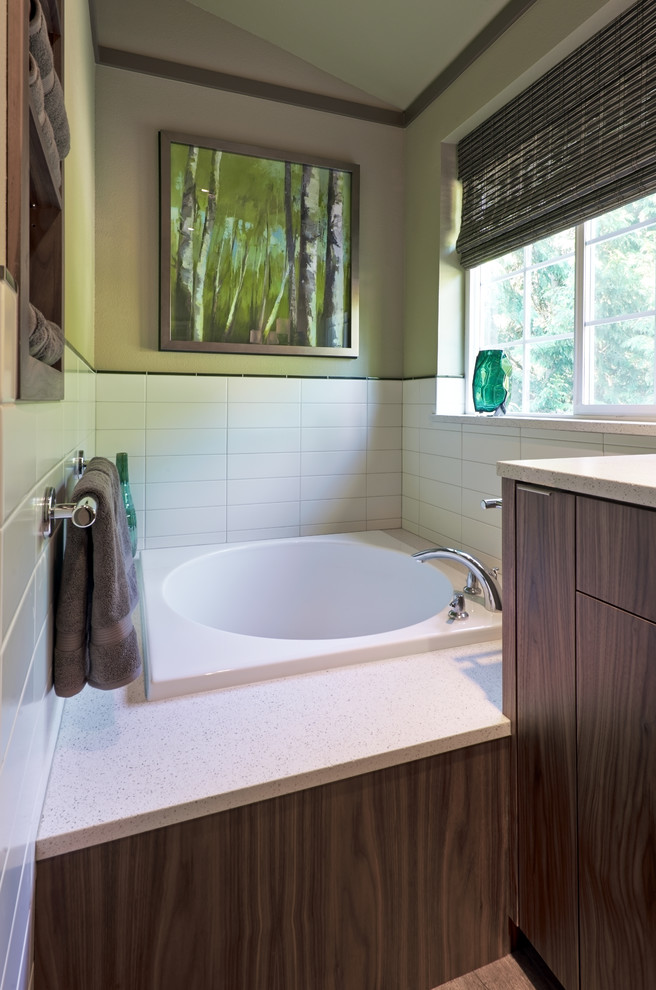 Example of a trendy master white tile and ceramic tile porcelain tile bathroom design in Portland with an undermount sink, flat-panel cabinets, medium tone wood cabinets, solid surface countertops, a one-piece toilet and green walls