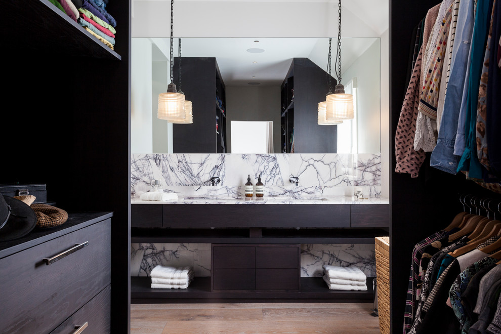 ロンドンにあるコンテンポラリースタイルのおしゃれなマスターバスルーム (アンダーカウンター洗面器、オープンシェルフ、濃色木目調キャビネット、大理石の洗面台、淡色無垢フローリング) の写真