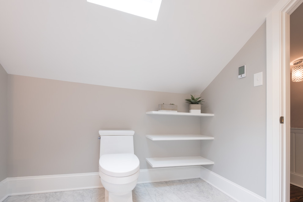 This is an example of a large traditional ensuite bathroom in Philadelphia with raised-panel cabinets, blue cabinets, an alcove shower, a two-piece toilet, white tiles, marble tiles, grey walls, marble flooring, a submerged sink, white floors, marble worktops and a hinged door.