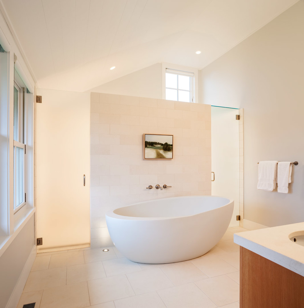 Пример оригинального дизайна: ванная комната в морском стиле с отдельно стоящей ванной, белой плиткой и окном