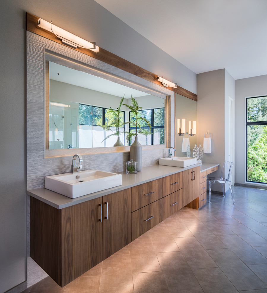 Modelo de cuarto de baño contemporáneo con armarios con paneles lisos, puertas de armario de madera oscura, paredes grises, lavabo sobreencimera, suelo gris y encimeras grises