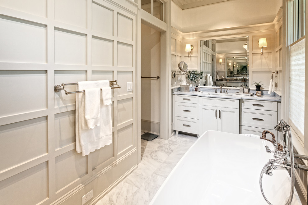 Example of a large transitional master marble floor and white floor bathroom design in Charleston with white walls, an undermount sink, a hinged shower door, recessed-panel cabinets, white cabinets and quartzite countertops