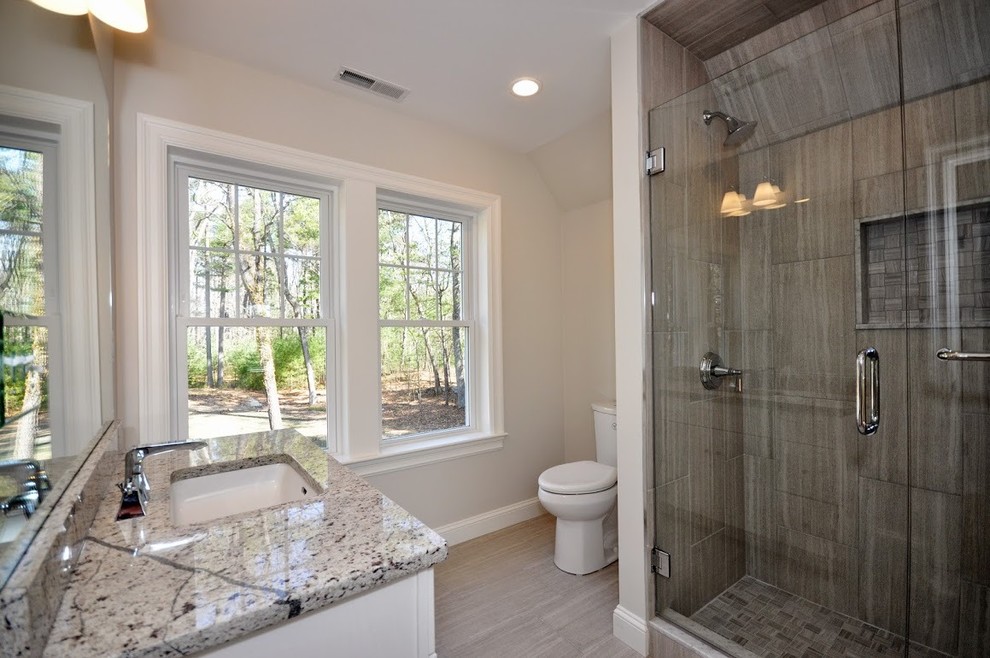 Exempel på ett mellanstort shabby chic-inspirerat badrum med dusch, med en dusch i en alkov, en toalettstol med separat cisternkåpa, beige väggar, klinkergolv i porslin, ett undermonterad handfat och granitbänkskiva