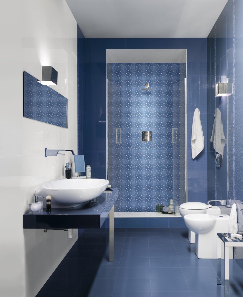 Diseño de cuarto de baño minimalista de tamaño medio con ducha empotrada, sanitario de una pieza, paredes azules, suelo de baldosas de cerámica, aseo y ducha, lavabo sobreencimera, baldosas y/o azulejos blancos y baldosas y/o azulejos en mosaico