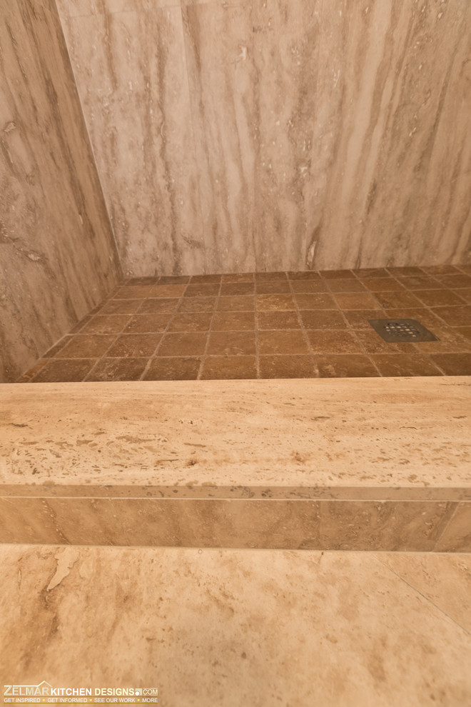 Klassisk inredning av ett litet badrum, med luckor med upphöjd panel, skåp i mellenmörkt trä, granitbänkskiva, en dusch/badkar-kombination, beige kakel, stenkakel och travertin golv