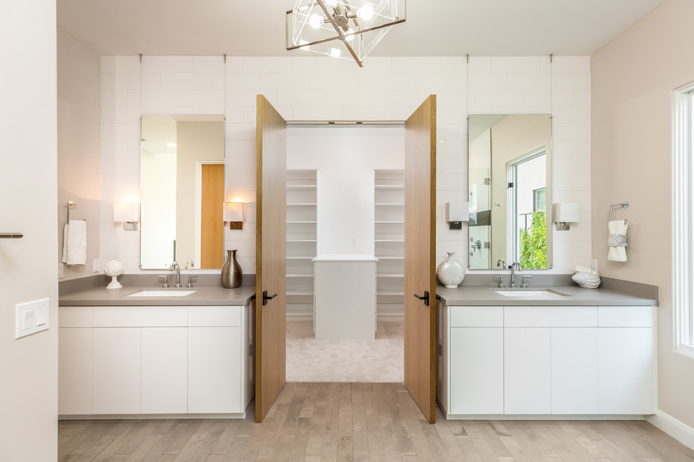 Inspiration for a large modern master light wood floor and brown floor bathroom remodel in Phoenix with flat-panel cabinets, white cabinets, beige walls, an undermount sink, gray countertops and a hinged shower door