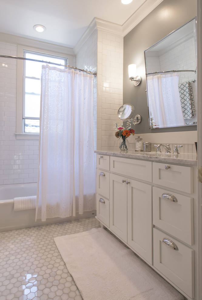 Foto på ett litet vintage en-suite badrum, med ett undermonterad handfat, skåp i shakerstil, vita skåp, marmorbänkskiva, ett badkar i en alkov, en dusch/badkar-kombination, vit kakel, tunnelbanekakel, grå väggar, marmorgolv och dusch med duschdraperi