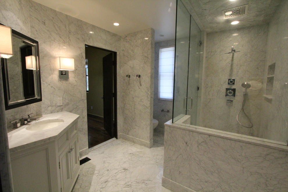 Idée de décoration pour une grande salle de bain principale tradition avec un lavabo intégré, un placard avec porte à panneau encastré, des portes de placard blanches, un plan de toilette en marbre, une douche ouverte, un carrelage blanc, un mur blanc et un sol en marbre.