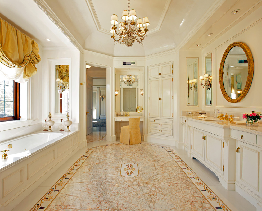 На фото: огромная главная ванная комната в классическом стиле с фасадами с утопленной филенкой, полновстраиваемой ванной и врезной раковиной с