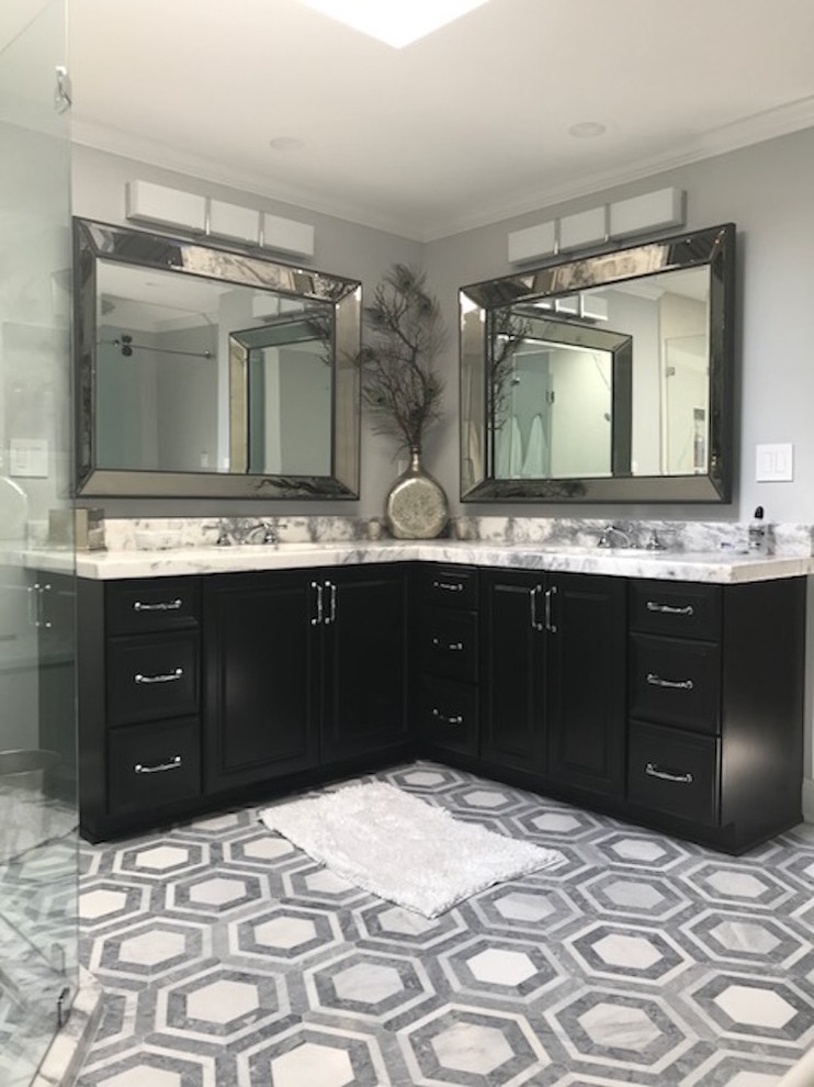 Inspiration for a mid-sized transitional master white tile and stone slab marble floor and multicolored floor corner shower remodel in New York with raised-panel cabinets, black cabinets, marble countertops, gray walls, an undermount sink and a hinged shower door