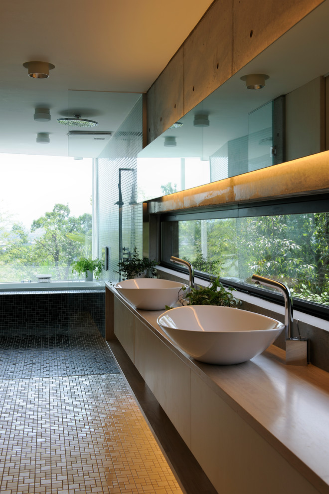 Идея дизайна: ванная комната в стиле модернизм с плоскими фасадами, накладной ванной, бежевой плиткой, серыми стенами, настольной раковиной, полом из керамогранита и зеркалом с подсветкой
