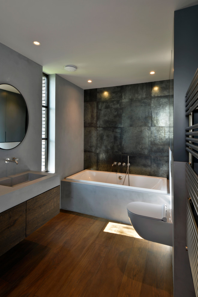 Idéer för ett mellanstort industriellt en-suite badrum, med ett platsbyggt badkar, en vägghängd toalettstol, mörkt trägolv, ett väggmonterat handfat och brunt golv