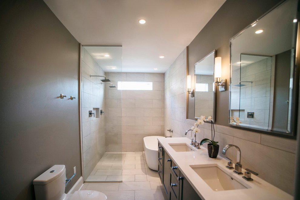 Example of a minimalist master beige tile and porcelain tile porcelain tile bathroom design in DC Metro with shaker cabinets, dark wood cabinets, a one-piece toilet, beige walls, an undermount sink and quartz countertops