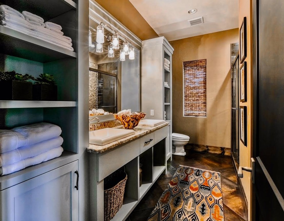 This is an example of a medium sized rustic ensuite bathroom in Other with freestanding cabinets, grey cabinets, an alcove shower, brown walls, dark hardwood flooring, a built-in sink, granite worktops, brown floors and a sliding door.