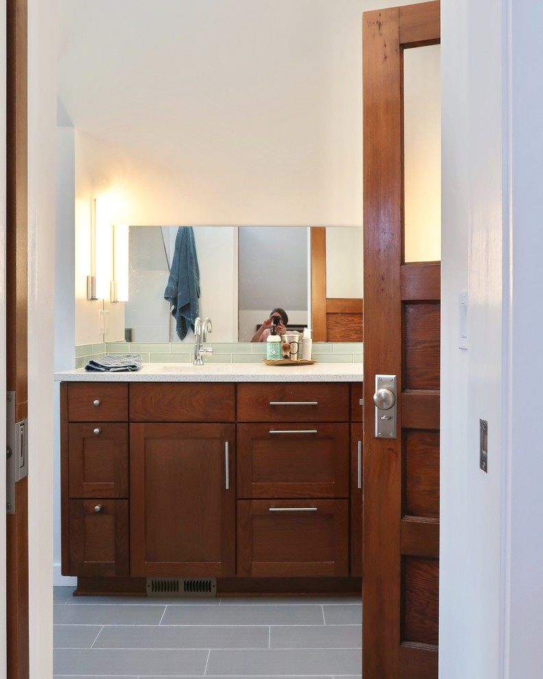 Mid-sized arts and crafts master blue tile and glass tile ceramic tile and gray floor bathroom photo in Portland with shaker cabinets, medium tone wood cabinets, a wall-mount toilet, white walls, an undermount sink, quartz countertops and a hinged shower door