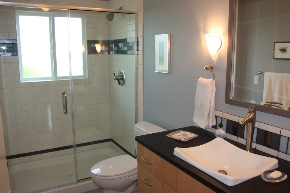 Idee per una stanza da bagno moderna di medie dimensioni con ante lisce, ante in legno scuro, doccia doppia, piastrelle blu, piastrelle di vetro, pareti blu, lavabo a bacinella e porta doccia a battente