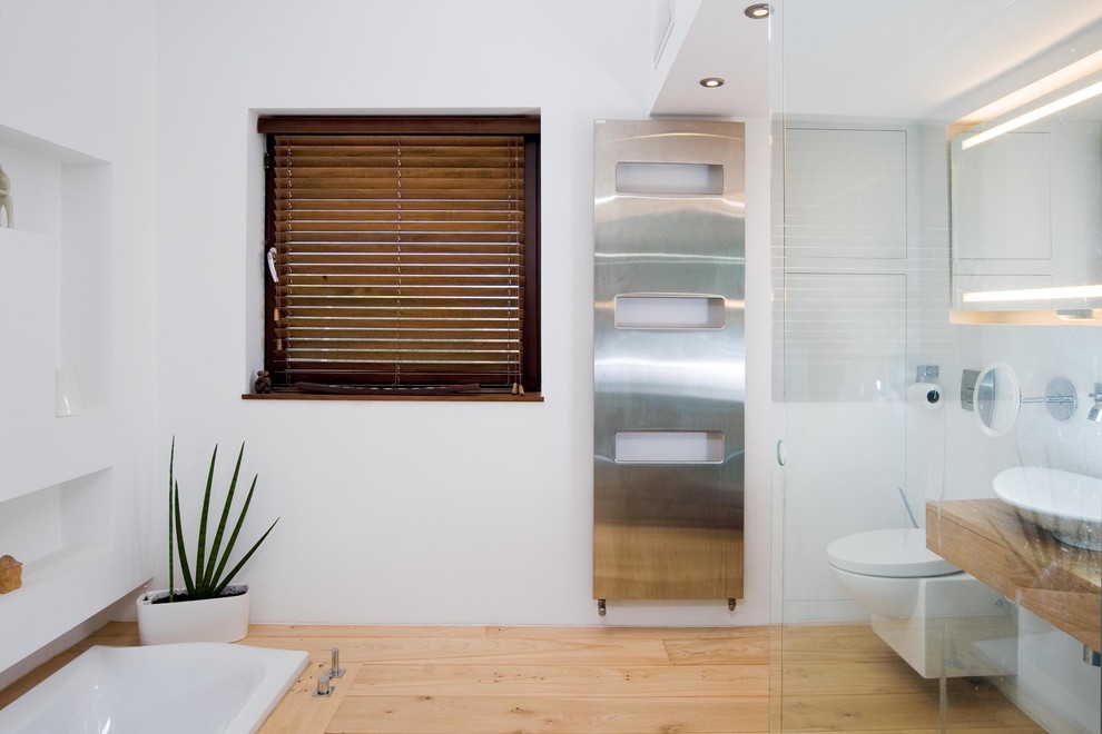Foto de cuarto de baño contemporáneo con lavabo sobreencimera, sanitario de pared y espejo con luz