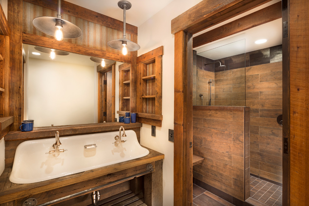 Foto på ett mellanstort rustikt brun en-suite badrum, med öppna hyllor, skåp i slitet trä, brun kakel, porslinskakel, beige väggar, ett avlångt handfat, träbänkskiva, en öppen dusch, klinkergolv i porslin och med dusch som är öppen