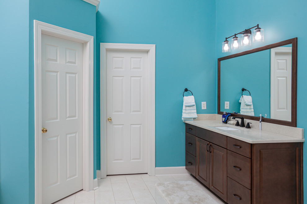 Idéer för att renovera ett mellanstort funkis en-suite badrum, med släta luckor, skåp i mellenmörkt trä, ett platsbyggt badkar, porslinskakel, blå väggar, klinkergolv i porslin, ett undermonterad handfat, bänkskiva i kvarts och dusch med gångjärnsdörr