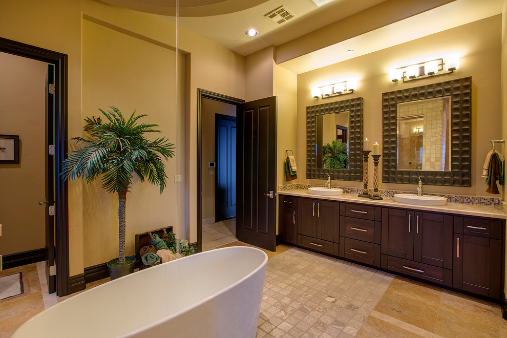 ラスベガスにあるアジアンスタイルのおしゃれな浴室 (オーバーカウンターシンク、シェーカースタイル扉のキャビネット、濃色木目調キャビネット、置き型浴槽、黄色い壁) の写真