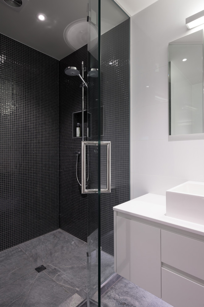 Kleines Modernes Badezimmer mit Trogwaschbecken, flächenbündigen Schrankfronten, weißen Schränken, Mineralwerkstoff-Waschtisch, Eckdusche, Toilette mit Aufsatzspülkasten, weißen Fliesen, Mosaikfliesen, weißer Wandfarbe und Keramikboden in Auckland