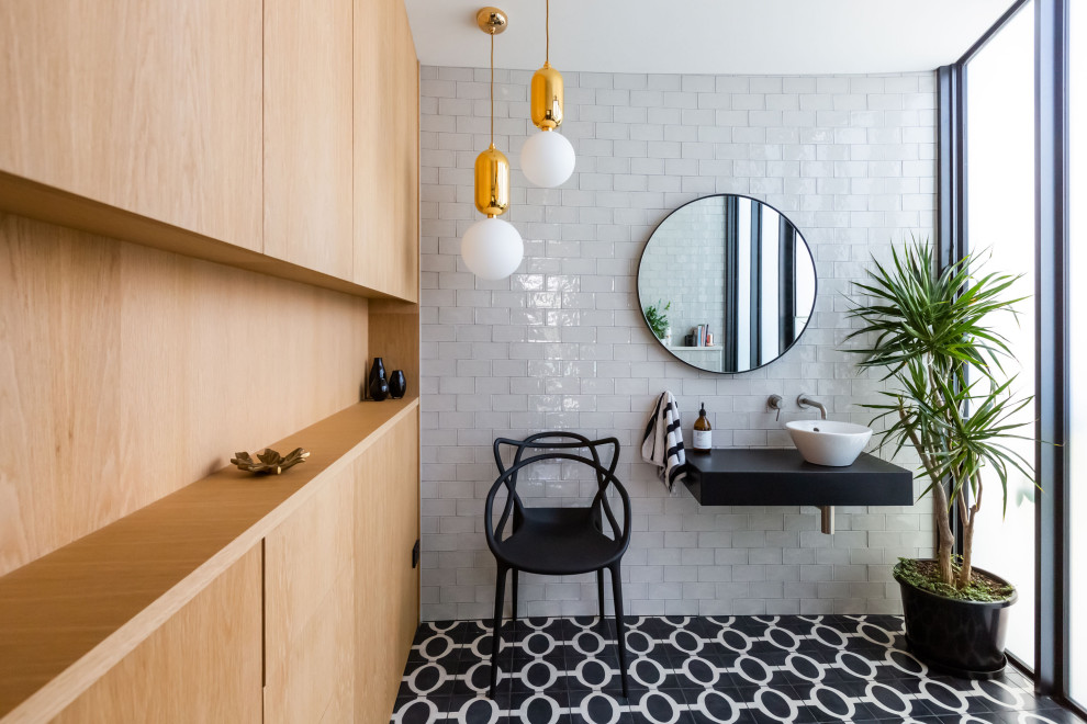 Inspiration pour une salle de bain design avec un carrelage blanc, un carrelage métro, une vasque, un sol noir, un plan de toilette noir, meuble simple vasque et meuble-lavabo suspendu.