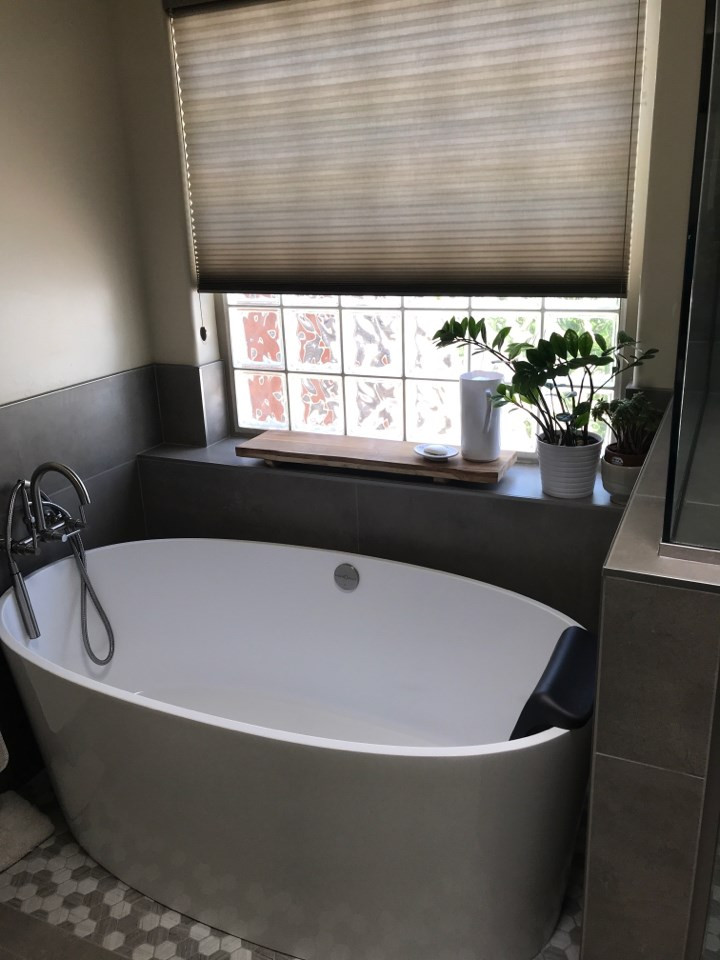Immagine di una grande stanza da bagno minimalista con vasca freestanding, doccia ad angolo e porta doccia a battente