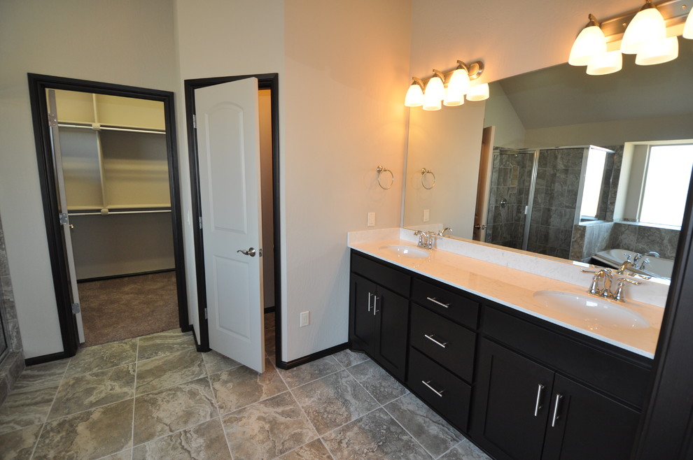 Photo of a medium sized traditional ensuite bathroom in Oklahoma City with shaker cabinets, medium wood cabinets, ceramic flooring, a hot tub, a corner shower, a two-piece toilet, grey tiles, ceramic tiles, grey walls, a submerged sink and marble worktops.