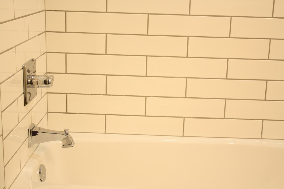 オクラホマシティにあるお手頃価格の中くらいなトラディショナルスタイルのおしゃれなバスルーム (浴槽なし) (シェーカースタイル扉のキャビネット、白いキャビネット、ドロップイン型浴槽、シャワー付き浴槽	、分離型トイレ、白いタイル、サブウェイタイル、グレーの壁、セラミックタイルの床、アンダーカウンター洗面器、大理石の洗面台) の写真