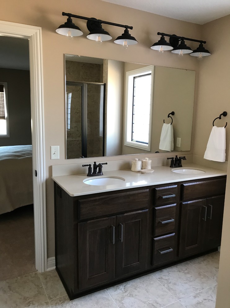 Example of a mid-sized classic master beige tile and porcelain tile porcelain tile and beige floor alcove shower design in Other with recessed-panel cabinets, dark wood cabinets, beige walls, an undermount sink, quartz countertops and a hinged shower door