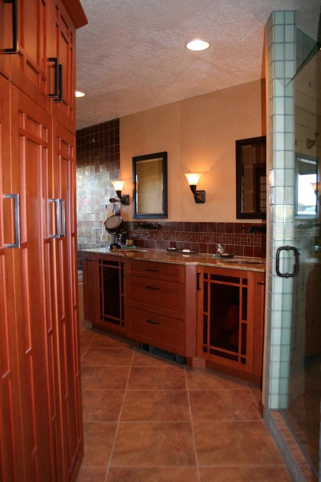 Exemple d'une douche en alcôve principale chic en bois brun de taille moyenne avec un mur beige, un sol en carrelage de céramique, un sol marron, une baignoire d'angle, un lavabo encastré, une cabine de douche à porte battante, un carrelage multicolore, des carreaux de céramique, un plan de toilette en stratifié et un placard avec porte à panneau encastré.