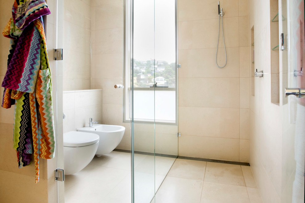 Inspiration for a mid-sized contemporary master bathroom in Sydney with flat-panel cabinets, light wood cabinets, a corner shower, a wall-mount toilet, ceramic tile, ceramic floors, an integrated sink, granite benchtops, beige floor and a hinged shower door.